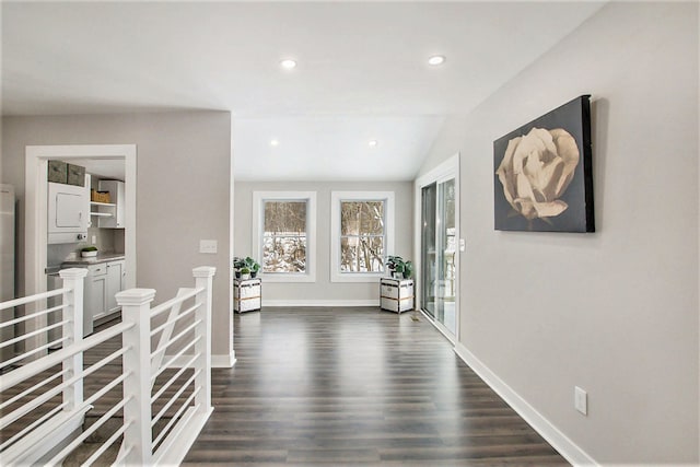 hallway with vaulted ceiling and dark hardwood / wood-style floors