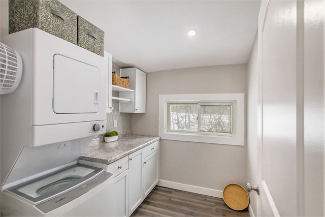 kitchen with white cabinetry, stacked washer / dryer, and dark hardwood / wood-style flooring