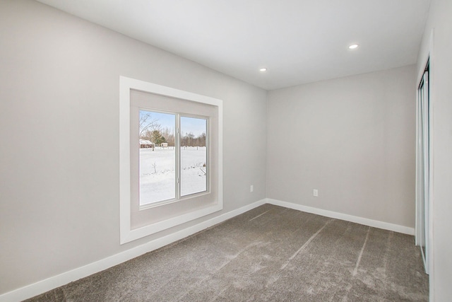 unfurnished room featuring dark colored carpet