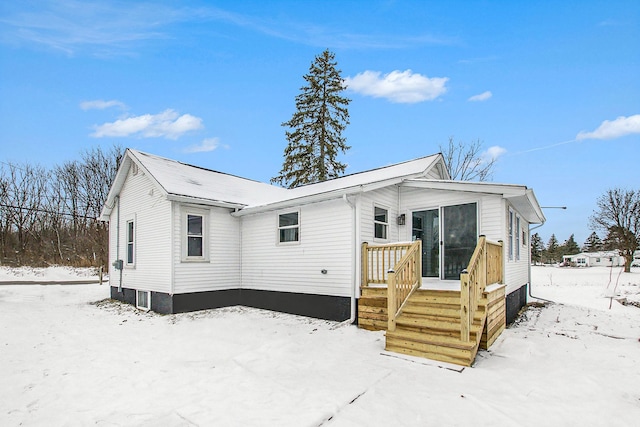 view of snow covered rear of property