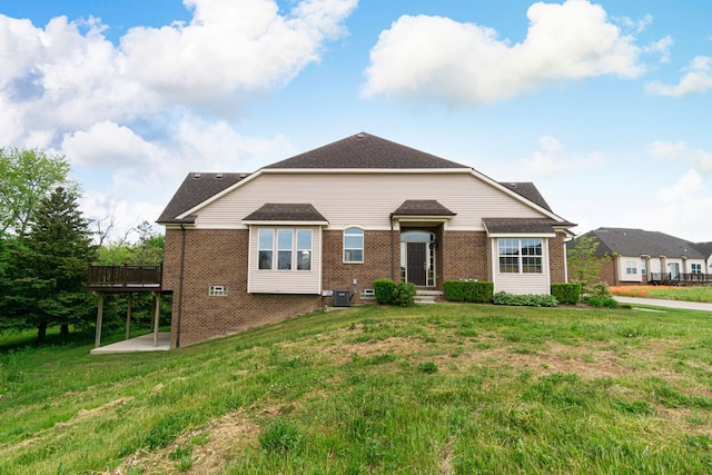 view of front of house with a deck, cooling unit, and a front lawn