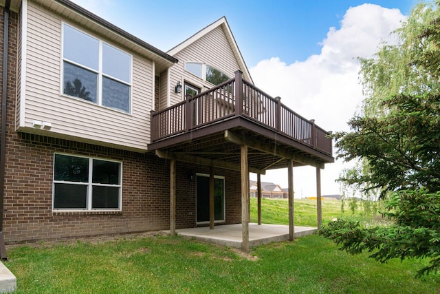 rear view of property featuring a patio, a yard, and a wooden deck