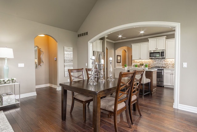 dining space with high vaulted ceiling, dark hardwood / wood-style flooring, and ornamental molding