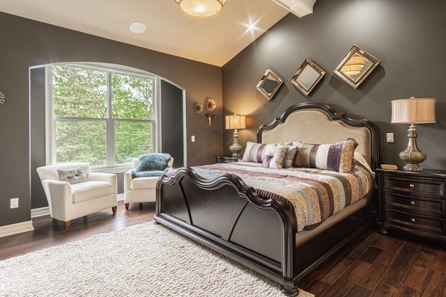 bedroom with multiple windows, vaulted ceiling with beams, and dark hardwood / wood-style floors