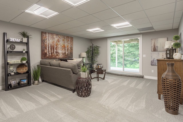 living room featuring carpet floors and a drop ceiling