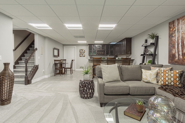 carpeted living room with a paneled ceiling