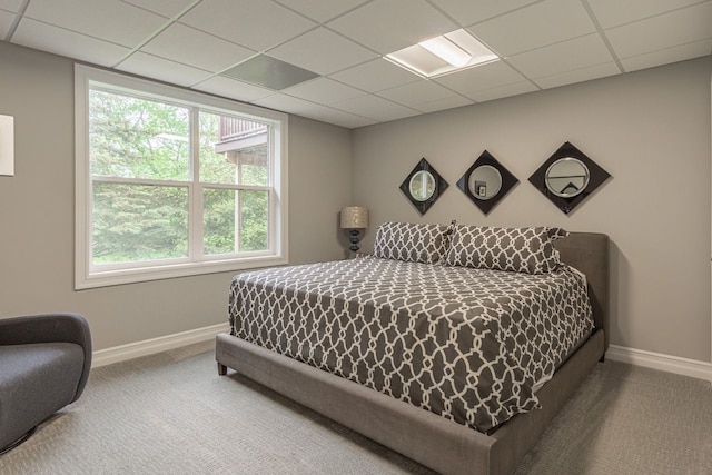 carpeted bedroom featuring a drop ceiling