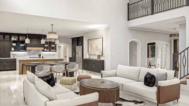 living room featuring crown molding and light hardwood / wood-style flooring