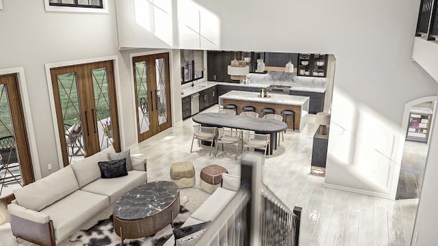 living room with french doors, light wood-type flooring, and a high ceiling