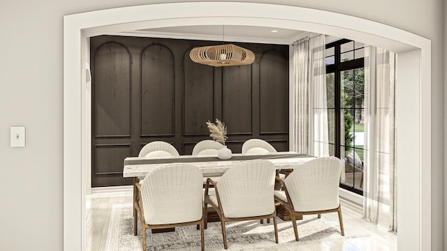 dining area featuring light wood-type flooring and crown molding