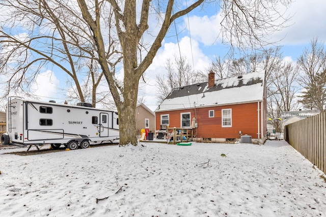 snow covered back of property with cooling unit