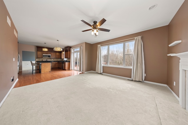 unfurnished living room with ceiling fan and light carpet