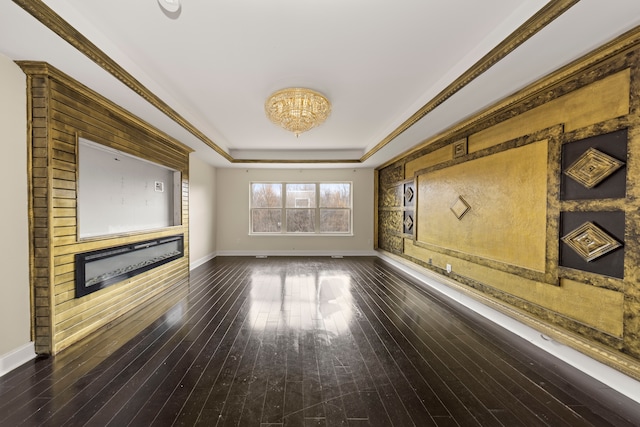 unfurnished living room with a raised ceiling, dark hardwood / wood-style flooring, and ornamental molding