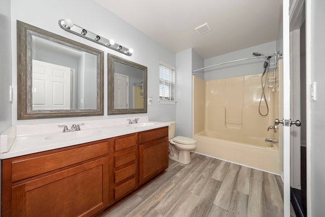 full bathroom with hardwood / wood-style floors, vanity, toilet, and shower / tub combination