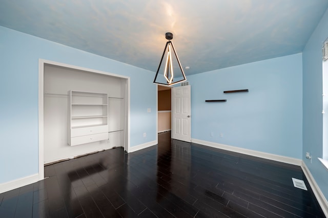 unfurnished living room with built in features and dark hardwood / wood-style floors