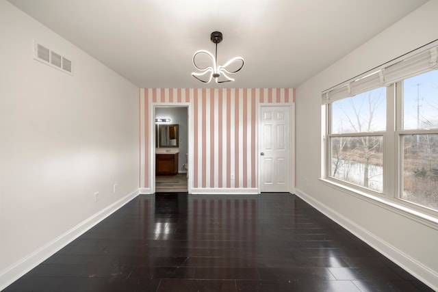 unfurnished dining area featuring a notable chandelier and dark wood-type flooring