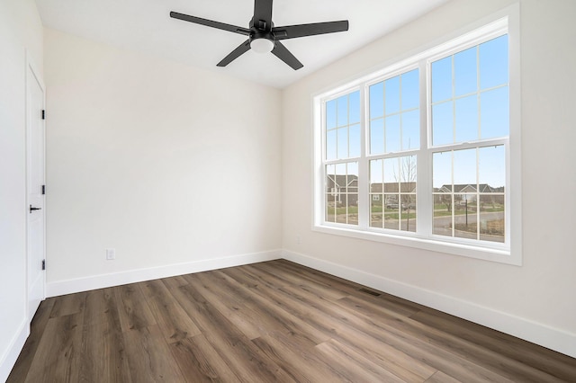 spare room with a wealth of natural light, dark hardwood / wood-style flooring, and ceiling fan