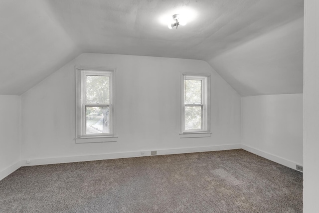 bonus room with carpet flooring and vaulted ceiling