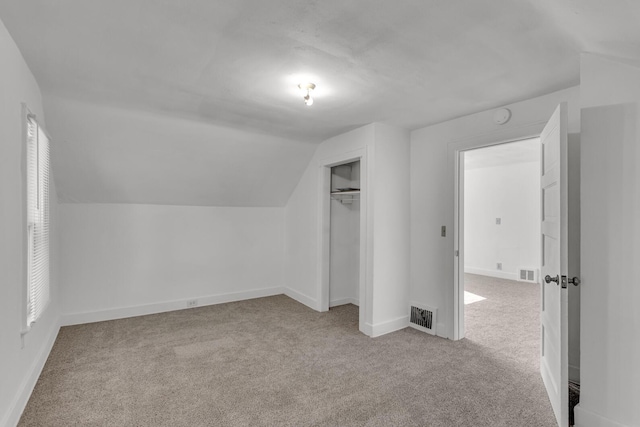 bonus room featuring light colored carpet and vaulted ceiling