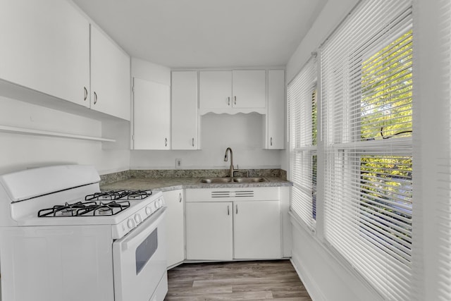 kitchen with sink, white cabinetry, and white gas range oven