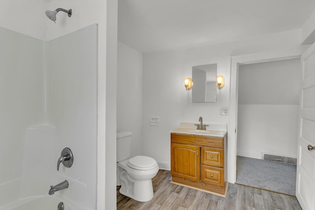 full bathroom featuring toilet, vanity, wood-type flooring, and tub / shower combination