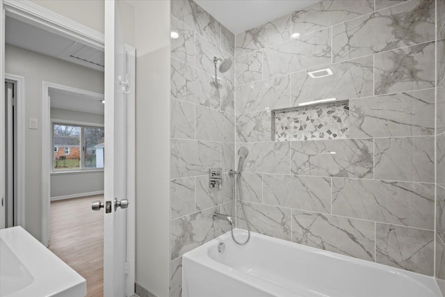 bathroom with hardwood / wood-style floors and tiled shower / bath