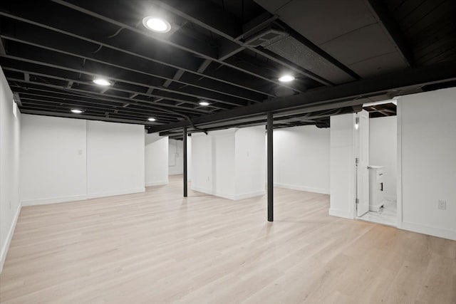 basement with light hardwood / wood-style floors