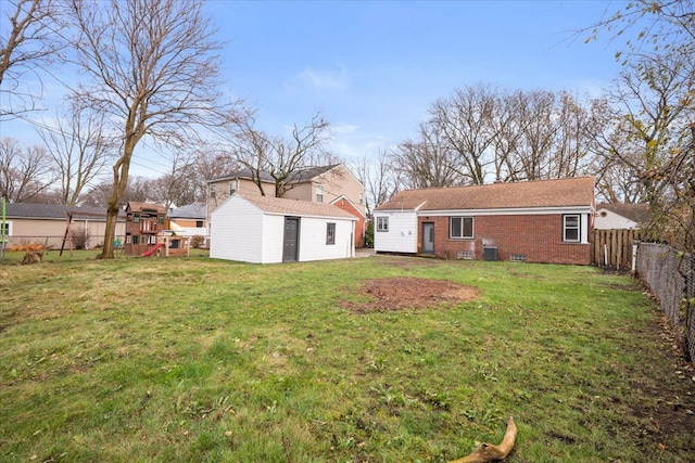 back of house with a lawn and an outdoor structure