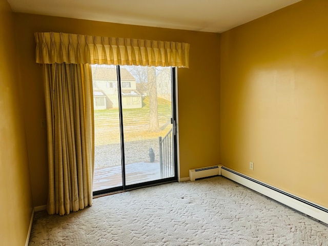 spare room featuring baseboard heating and carpet