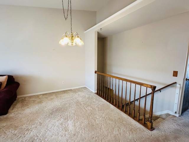 carpeted spare room featuring an inviting chandelier