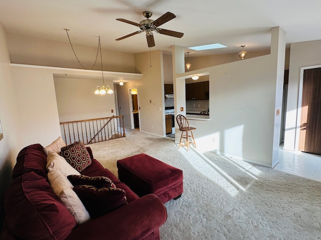 living room with carpet flooring, ceiling fan with notable chandelier, and vaulted ceiling with skylight