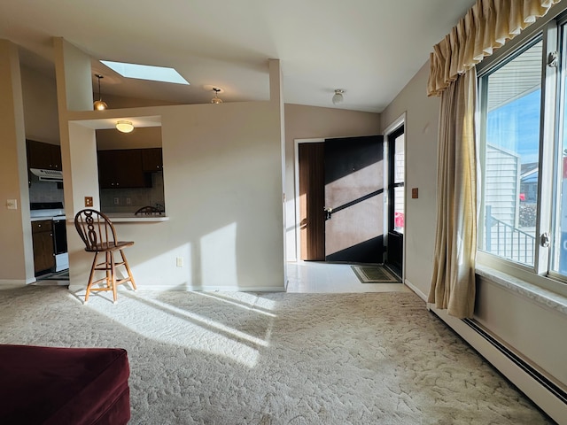 entryway featuring vaulted ceiling with skylight, light colored carpet, and a baseboard heating unit