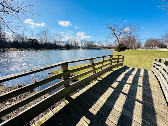 dock area with a yard and a water view