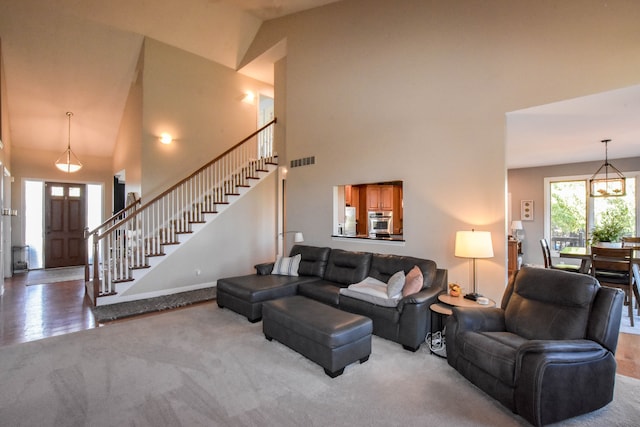 carpeted living room with high vaulted ceiling