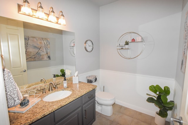 bathroom with tile patterned flooring, vanity, and toilet