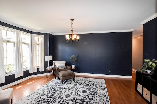 sitting room with a chandelier, dark hardwood / wood-style flooring, and ornamental molding