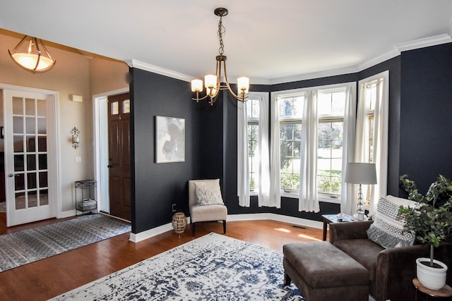 sitting room with a chandelier, dark hardwood / wood-style flooring, and crown molding