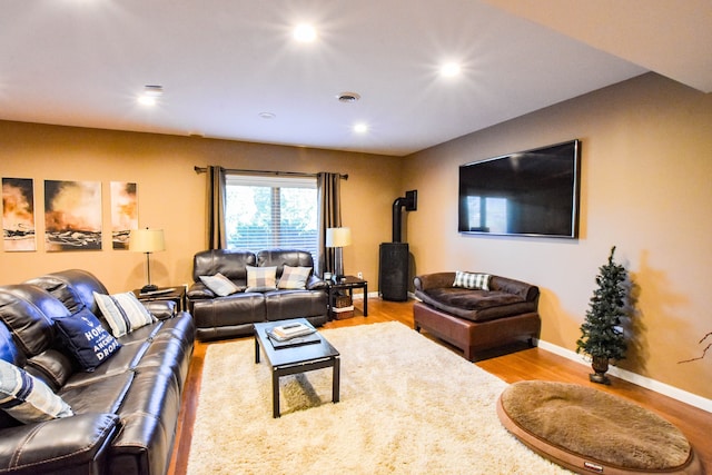 living room featuring a wood stove and hardwood / wood-style floors