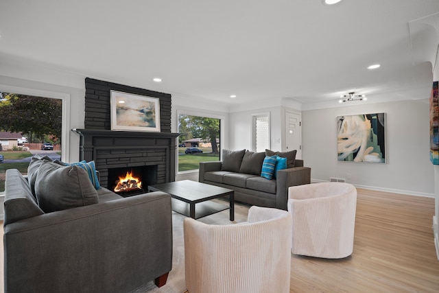 living room featuring a stone fireplace and light hardwood / wood-style flooring