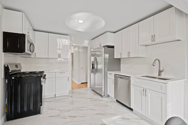 kitchen featuring tasteful backsplash, white cabinetry, sink, and stainless steel appliances