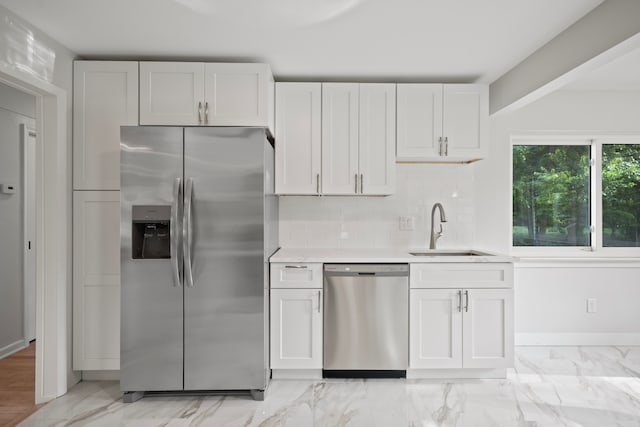 kitchen with white cabinets, decorative backsplash, sink, and appliances with stainless steel finishes