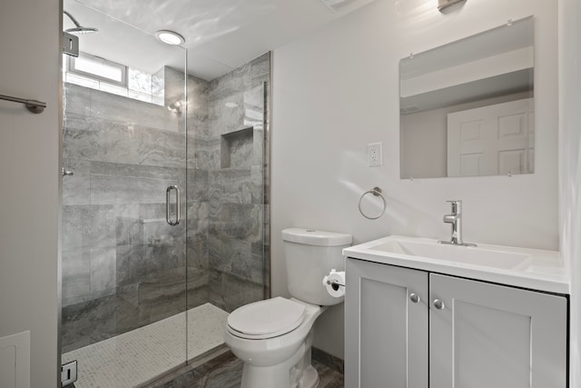 bathroom with vanity, toilet, and a shower with shower door