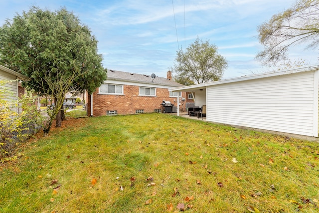 rear view of house featuring a lawn and a patio