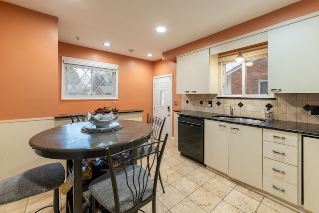 kitchen with dishwasher, white cabinetry, sink, and tasteful backsplash