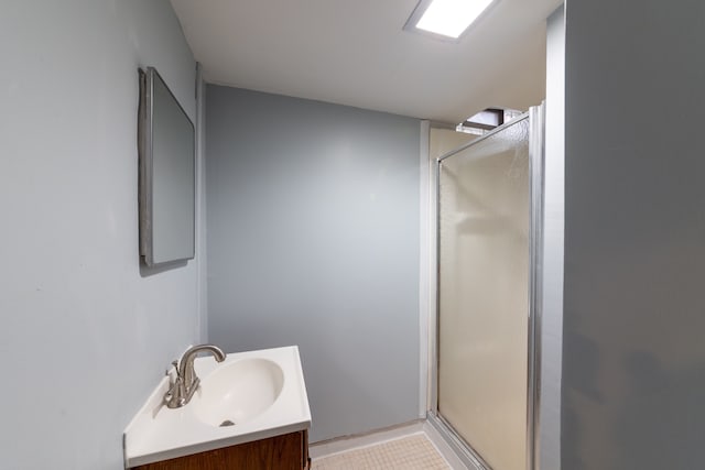 bathroom with a shower with door and vanity