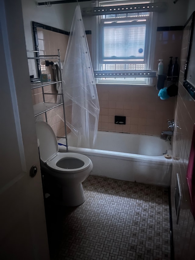 bathroom featuring shower / bath combo and toilet