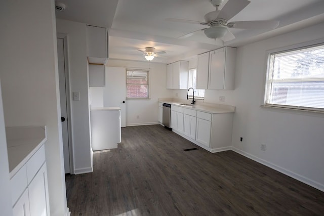 kitchen featuring stainless steel dishwasher, ceiling fan, dark wood-type flooring, sink, and white cabinetry