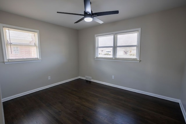 unfurnished room featuring plenty of natural light, dark wood-type flooring, and ceiling fan