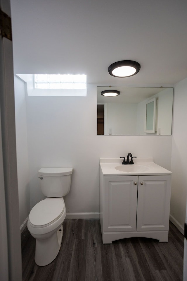 bathroom featuring vanity, hardwood / wood-style flooring, and toilet