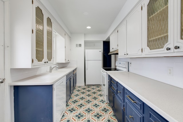 kitchen with blue cabinetry, white cabinetry, and white appliances